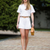 Young woman with blond hair wearing organic cotton white blouse t-shirt and organic cotton white shorts
