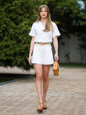 Young woman with blond hair wearing organic cotton white blouse t-shirt and organic cotton white shorts