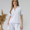 Young woman with blond hair wearing organic cotton white blouse t-shirt and organic cotton white shorts