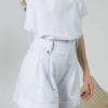Young woman with blond hair wearing organic cotton white blouse t-shirt and organic cotton white shorts