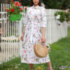 Woman wearing floral organic cotton shirt dress with bracelet sleeves coconut buttons and waist belt