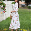 Woman wearing floral organic cotton shirt dress with bracelet sleeves coconut buttons and waist belt