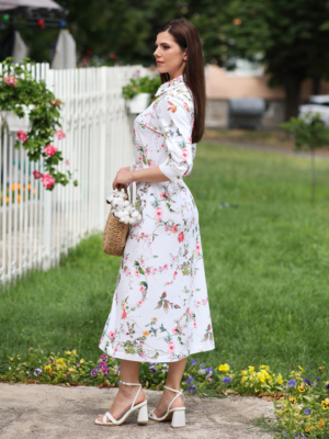 Woman wearing floral organic cotton shirt dress with bracelet sleeves coconut buttons and waist belt