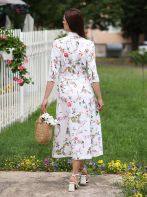 Woman wearing floral organic cotton shirt dress with bracelet sleeves coconut buttons and waist belt