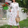 Woman wearing floral organic cotton shirt dress with bracelet sleeves coconut buttons and waist belt