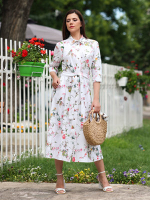 Woman wearing floral organic cotton shirt dress with bracelet sleeves coconut buttons and waist belt