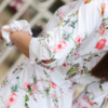 Woman wearing floral organic cotton shirt dress with bracelet sleeves coconut buttons and waist belt