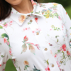 Woman wearing floral organic cotton shirt dress with bracelet sleeves coconut buttons and waist belt