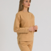 woman with blond hair wearing brown organic cotton long sleeve off shoulder boat neck blouse and brown organic cotton long tapered leg pants
