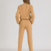 woman with blond hair wearing brown organic cotton long sleeve off shoulder boat neck blouse and brown organic cotton long tapered leg pants