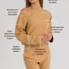woman with blond hair wearing brown organic cotton long sleeve off shoulder boat neck blouse and brown organic cotton long tapered leg pants