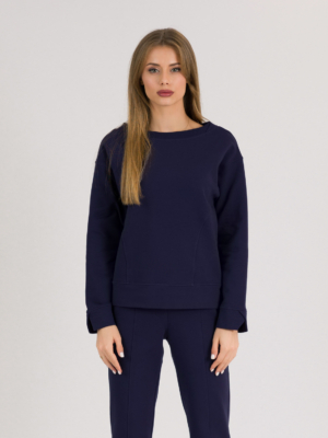 woman with blond hair wearing dark blue organic cotton long sleeve off shoulder boat neck blouse and dark blue organic cotton long tapered leg pants