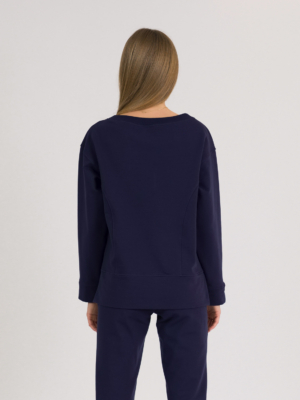woman with blond hair wearing dark blue organic cotton long sleeve off shoulder boat neck blouse and dark blue organic cotton long tapered leg pants