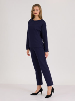 woman with blond hair wearing dark blue organic cotton long sleeve off shoulder boat neck blouse and dark blue organic cotton long tapered leg pants