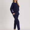 woman with blond hair wearing dark blue organic cotton long sleeve off shoulder boat neck blouse and dark blue organic cotton long tapered leg pants