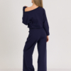 woman with blond hair wearing dark blue organic cotton long sleeve off shoulder boat neck blouse and dark blue organic cotton long wide legs pants