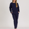 woman with blond hair wearing dark blue organic cotton oversized polo collar sweatshirt and dark blue organic cotton long tapered leg pants