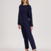 woman with blond hair wearing dark blue organic cotton oversized polo collar sweatshirt and dark blue organic cotton long tapered leg pants