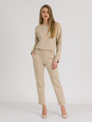woman with blond hair wearing beige organic cotton elegant blouse and beige organic cotton long tapered leg pants