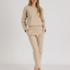 woman with blond hair wearing beige organic cotton elegant blouse and beige organic cotton long tapered leg pants
