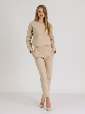 woman with blond hair wearing beige organic cotton elegant blouse and beige organic cotton long tapered leg pants