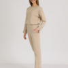 woman with blond hair wearing beige organic cotton elegant blouse and beige organic cotton long tapered leg pants