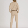 woman with blond hair wearing beige organic cotton elegant blouse and beige organic cotton long tapered leg pants