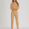 woman with blond hair wearing brown organic cotton elegant blouse and brown organic cotton long tapered leg pants