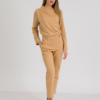 woman with blond hair wearing brown organic cotton elegant blouse and brown organic cotton long tapered leg pants