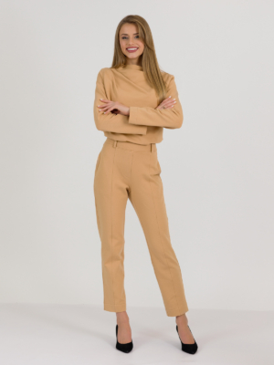 woman with blond hair wearing brown organic cotton elegant blouse and brown organic cotton long tapered leg pants
