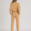 woman with blond hair wearing brown organic cotton elegant blouse and brown organic cotton long tapered leg pants