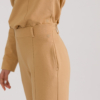 woman with blond hair wearing brown organic cotton elegant blouse and brown organic cotton long tapered leg pants