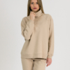 woman with blond hair wearing beige organic cotton oversized polo collar sweatshirt and beige organic cotton long tapered leg pants
