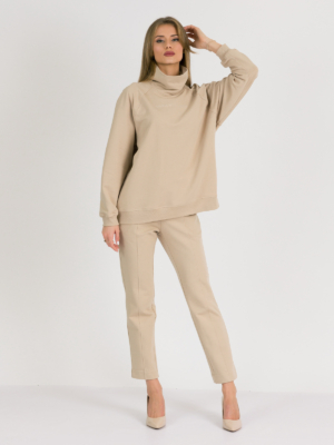 woman with blond hair wearing beige organic cotton oversized polo collar sweatshirt and beige organic cotton long tapered leg pants
