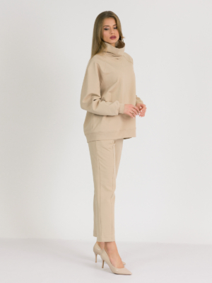 woman with blond hair wearing beige organic cotton oversized polo collar sweatshirt and beige organic cotton long tapered leg pants