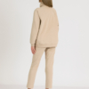 woman with blond hair wearing beige organic cotton oversized polo collar sweatshirt and beige organic cotton long tapered leg pants