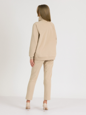 woman with blond hair wearing beige organic cotton oversized polo collar sweatshirt and beige organic cotton long tapered leg pants