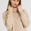 woman with blond hair wearing beige organic cotton oversized polo collar sweatshirt and beige organic cotton long wide pants