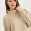 woman with blond hair wearing beige organic cotton oversized polo collar sweatshirt and beige organic cotton long wide pants