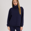 woman with blond hair wearing dark blue organic cotton oversized polo collar sweatshirt and dark blue organic cotton long tapered leg pants