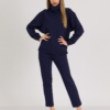 woman with blond hair wearing dark blue organic cotton oversized polo collar sweatshirt and dark blue organic cotton long tapered leg pants