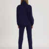 woman with blond hair wearing dark blue organic cotton oversized polo collar sweatshirt and dark blue organic cotton long tapered leg pants