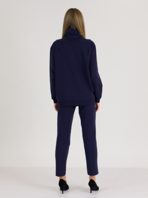 woman with blond hair wearing dark blue organic cotton oversized polo collar sweatshirt and dark blue organic cotton long tapered leg pants