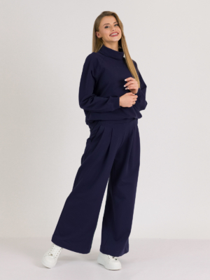 woman with blond hair wearing dark blue organic cotton oversized polo collar sweatshirt and dark blue organic cotton long wide pants