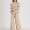 Woman with blond hair wearing beige organic cotton hoodie and beige long wide pants