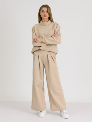 Woman with blond hair wearing beige organic cotton hoodie and beige long wide pants