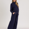 Woman with blond hair wearing organic cotton dark blue color hoodie and dark blue color long wide pants