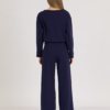 Woman with blond hair wearing organic cotton dark blue color blouse and dark blue color long wide pants