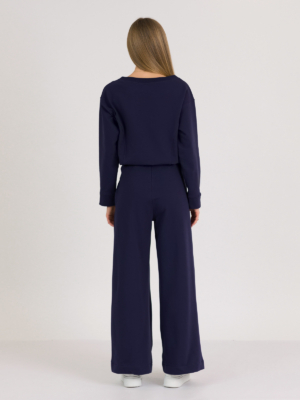Woman with blond hair wearing organic cotton dark blue color blouse and dark blue color long wide pants