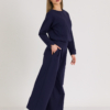Woman with blond hair wearing organic cotton dark blue color blouse and dark blue color long wide pants